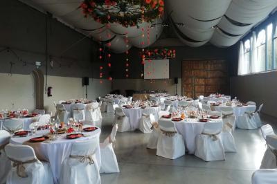 Miniature Location salle Héron (Liège) - Chateau Ferme de Marsinne #5 Salle de réception décorée avec des tables rondes dressées, des chaises blanches et un plafond orné de guirlandes suspendues.