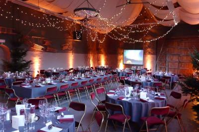 Miniature Location salle Héron (Liège) - Chateau Ferme de Marsinne #4 Salle de réception décorée avec des tables rondes dressées, des chaises blanches et un plafond orné de guirlandes suspendues.