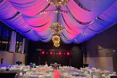 Cour intérieure d'un château avec pelouse, tables en bois, bâtiments en pierre et tours sous un ciel dégagé.