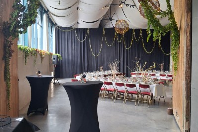 Cour intérieure d'un château avec pelouse, tables en bois, bâtiments en pierre et tours sous un ciel dégagé.