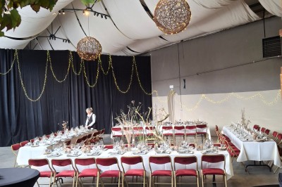 Cour intérieure d'un château avec pelouse, tables en bois, bâtiments en pierre et tours sous un ciel dégagé.