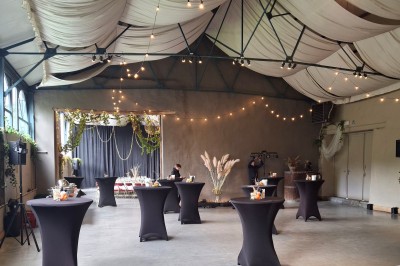 Cour intérieure d'un château avec pelouse, tables en bois, bâtiments en pierre et tours sous un ciel dégagé.