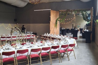 Cour intérieure d'un château avec pelouse, tables en bois, bâtiments en pierre et tours sous un ciel dégagé.