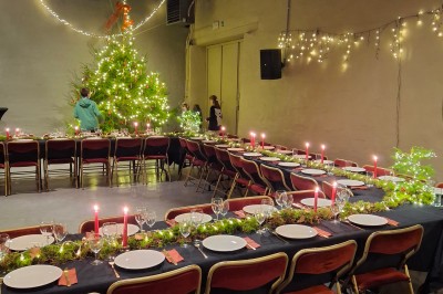 Cour intérieure d'un château avec pelouse, tables en bois, bâtiments en pierre et tours sous un ciel dégagé.
