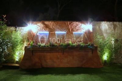 Miniature Location salle Vitrolles (Bouches-du-Rhône) - L'alizé #12 Mur en pierre ocre avec jardinières en bois garnies de fleurs colorées, entouré de végétation et éclairé par la lumière du…