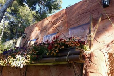 Miniature Location salle Vitrolles (Bouches-du-Rhône) - L'alizé #23 Mur en pierre ocre avec jardinières en bois garnies de fleurs colorées, entouré de végétation et éclairé par la lumière du…