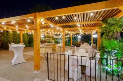 Miniature Location salle Vitrolles (Bouches-du-Rhône) - L'alizé #5 Mur en pierre ocre avec jardinières en bois garnies de fleurs colorées, entouré de végétation et éclairé par la lumière du…