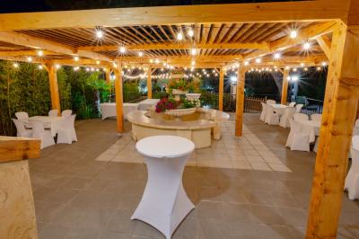 Miniature Location salle Vitrolles (Bouches-du-Rhône) - L'alizé #6 Mur en pierre ocre avec jardinières en bois garnies de fleurs colorées, entouré de végétation et éclairé par la lumière du…