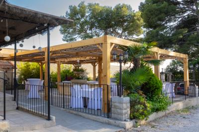 Miniature Location salle Vitrolles (Bouches-du-Rhône) - L'alizé #4 Mur en pierre ocre avec jardinières en bois garnies de fleurs colorées, entouré de végétation et éclairé par la lumière du…