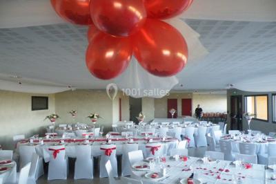Bâtiment à un étage avec toit en tuiles, entouré de chemins, de pelouse et de vignes en arrière-plan.