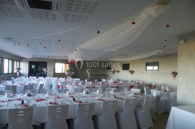 Bâtiment à un étage avec toit en tuiles, entouré de chemins, de pelouse et de vignes en arrière-plan.