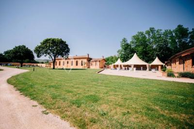 Chambre avec lit double, parquet clair, échelle en bois menant à une mezzanine, fenêtre avec rideaux et miroir debout.