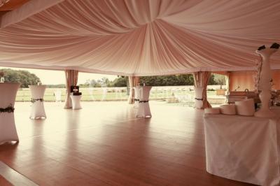 Chambre avec lit double, parquet clair, échelle en bois menant à une mezzanine, fenêtre avec rideaux et miroir debout.