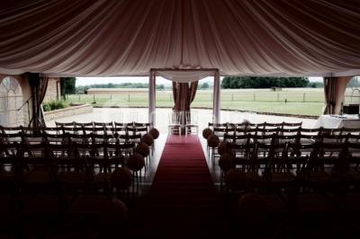 Chambre avec lit double, parquet clair, échelle en bois menant à une mezzanine, fenêtre avec rideaux et miroir debout.
