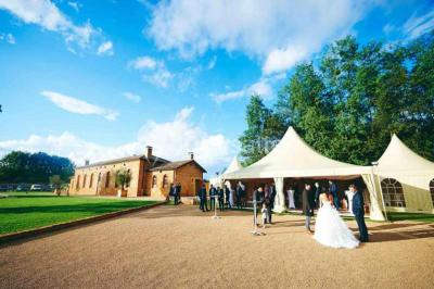 Chambre avec lit double, parquet clair, échelle en bois menant à une mezzanine, fenêtre avec rideaux et miroir debout.