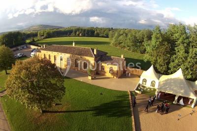 Chambre avec lit double, parquet clair, échelle en bois menant à une mezzanine, fenêtre avec rideaux et miroir debout.