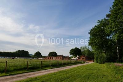 Chambre avec lit double, parquet clair, échelle en bois menant à une mezzanine, fenêtre avec rideaux et miroir debout.