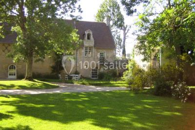 Miniature Location salle Gonneville-en-Auge (Calvados) - Château de Merville #12 Salle à manger rustique avec murs en pierre, table en bois, chaises assorties et porte-fenêtre donnant sur l'extérieur.
