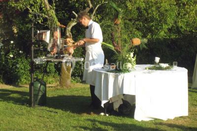 Miniature Location salle Gonneville-en-Auge (Calvados) - Château de Merville #14 Salle à manger rustique avec murs en pierre, table en bois, chaises assorties et porte-fenêtre donnant sur l'extérieur.