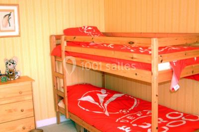 Miniature Location salle Gonneville-en-Auge (Calvados) - Château de Merville #20 Salle à manger rustique avec murs en pierre, table en bois, chaises assorties et porte-fenêtre donnant sur l'extérieur.