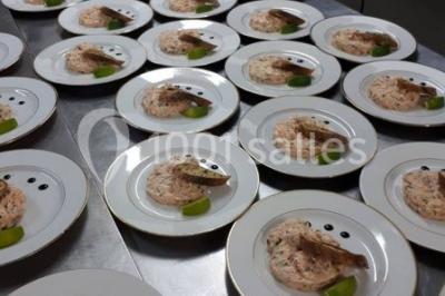 Plateaux de bouchées apéritives variées disposés sur des supports en bois dans un cadre extérieur.