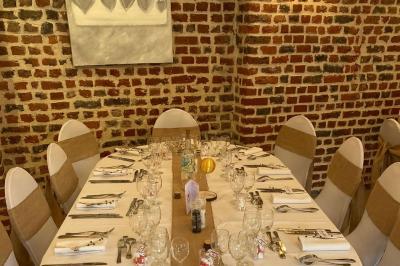 Jambon sur support, bol de tartare et croûtons disposés sur une table devant un mur en briques.