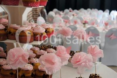Jambon sur support, bol de tartare et croûtons disposés sur une table devant un mur en briques.