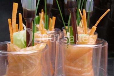 Jambon sur support, bol de tartare et croûtons disposés sur une table devant un mur en briques.