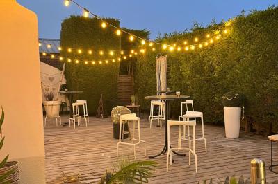 Jambon sur support, bol de tartare et croûtons disposés sur une table devant un mur en briques.