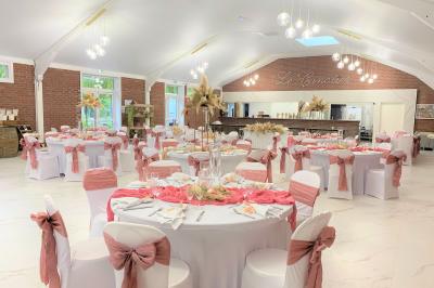 Miniature Location salle Paillencourt (Nord) - Le Canotier #8 Table en bois décorée de bougies, fleurs et feuillage, entourée de chaises, sous une arche végétale dans une salle lumineuse.