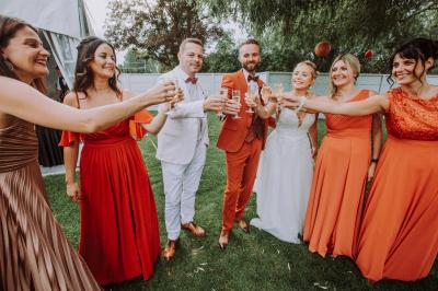 Miniature Location salle Paillencourt (Nord) - Le Canotier #17 Table en bois décorée de bougies, fleurs et feuillage, entourée de chaises, sous une arche végétale dans une salle lumineuse.