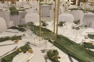 Miniature Location salle Paillencourt (Nord) - Le Canotier #22 Table en bois décorée de bougies, fleurs et feuillage, entourée de chaises, sous une arche végétale dans une salle lumineuse.