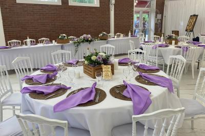Miniature Location salle Paillencourt (Nord) - Le Canotier #25 Table en bois décorée de bougies, fleurs et feuillage, entourée de chaises, sous une arche végétale dans une salle lumineuse.