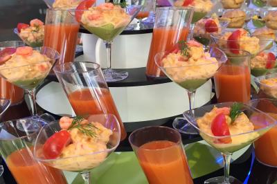 Miniature Location salle Paillencourt (Nord) - Le Canotier #42 Table en bois décorée de bougies, fleurs et feuillage, entourée de chaises, sous une arche végétale dans une salle lumineuse.