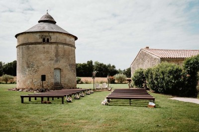 Bâtiment en pierre éclairé la nuit, avec un ciel bleu foncé en arrière-plan et un jardin sombre au premier plan.