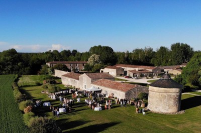 Bâtiment en pierre éclairé la nuit, avec un ciel bleu foncé en arrière-plan et un jardin sombre au premier plan.