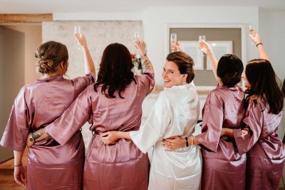 Bâtiment en pierre éclairé la nuit, avec un ciel bleu foncé en arrière-plan et un jardin sombre au premier plan.