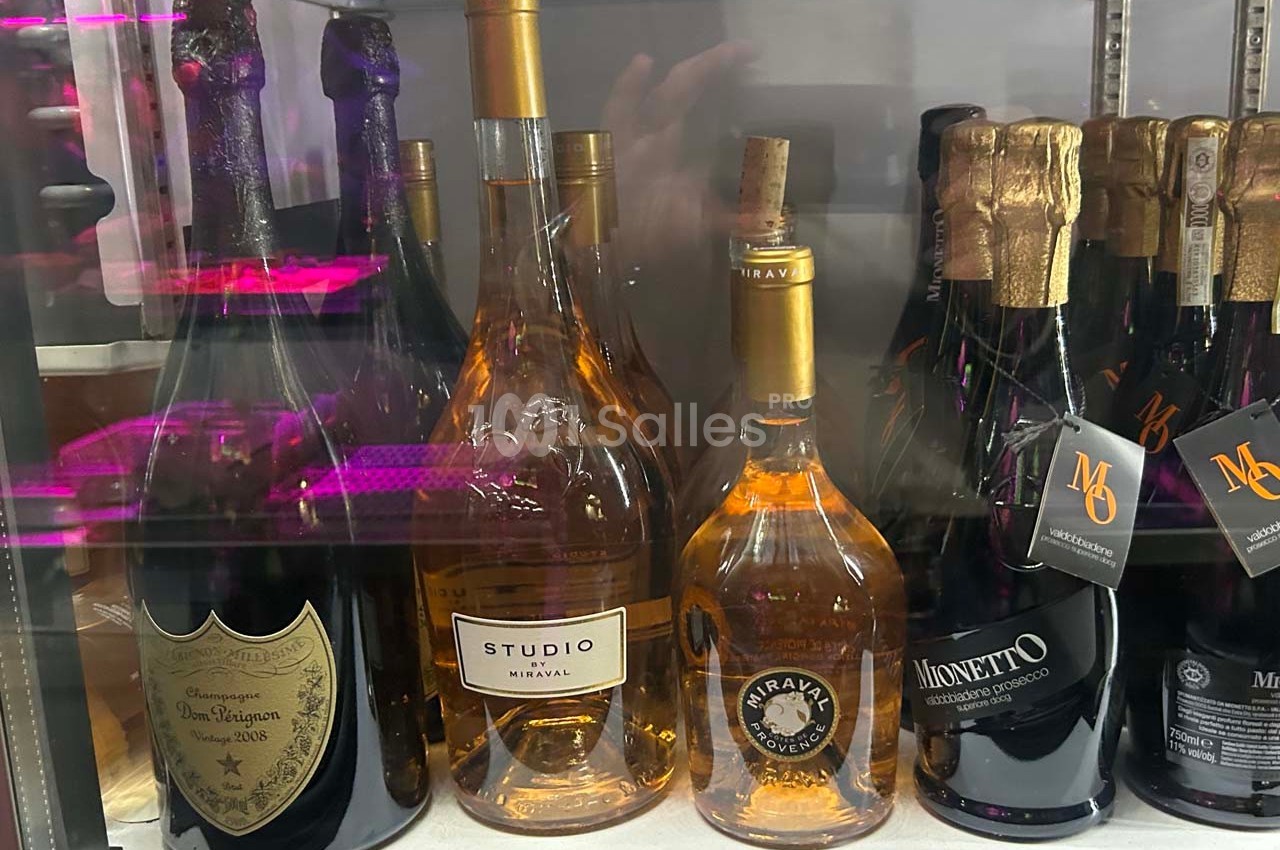 Bouteilles de vin et de champagne variées exposées dans un réfrigérateur.