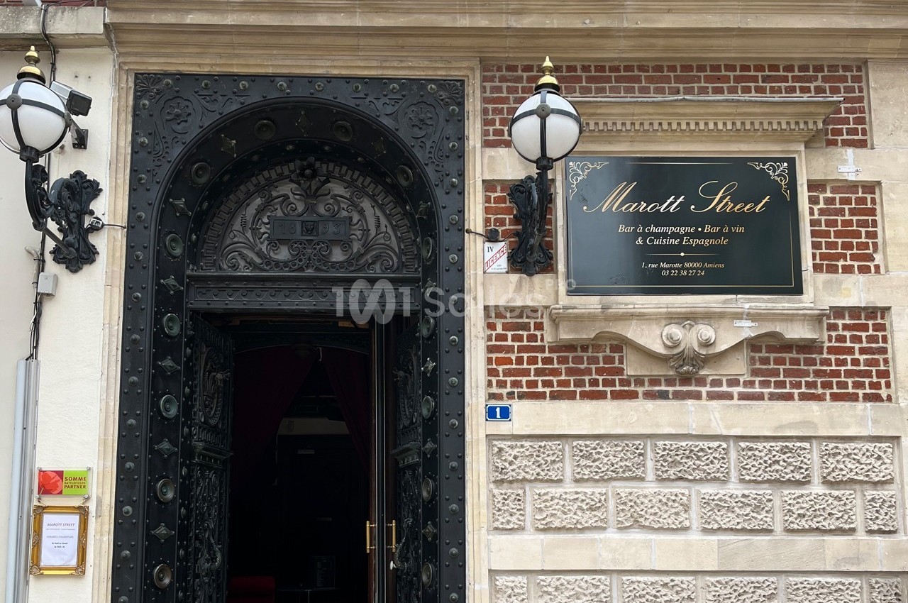 Entrée d'un bar à champagne et à vin avec une porte ornée et une plaque indiquant ’Marott Street’.