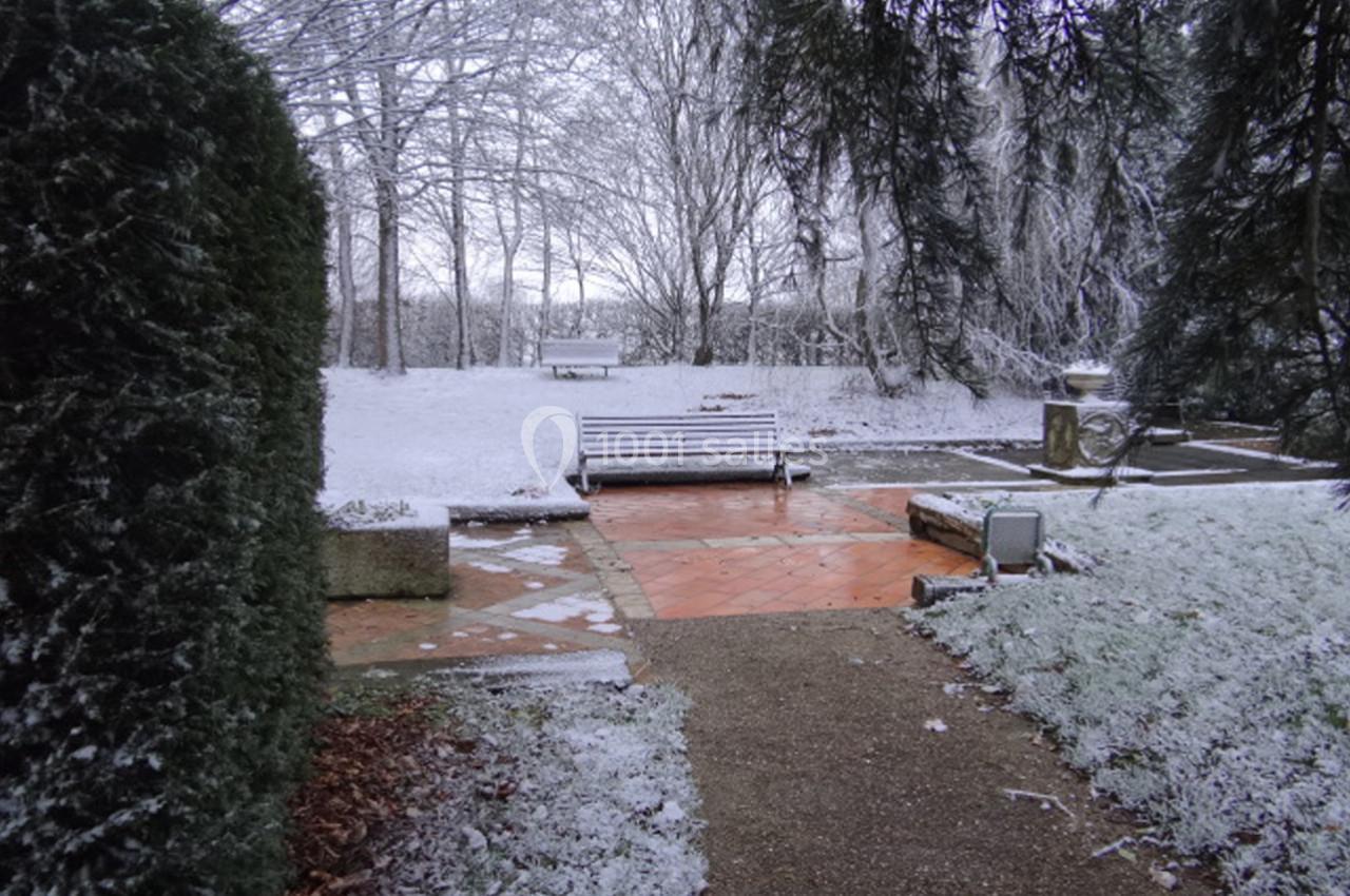 Location salle La Villeneuve-en-Chevrie (Yvelines) - La Grange des Mollières #22 Bancs et allées dans un parc enneigé entouré d'arbres et de végétation givrée.