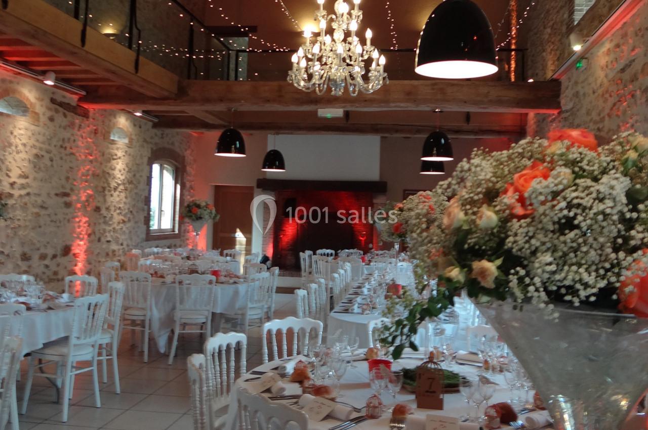 Location salle La Villeneuve-en-Chevrie (Yvelines) - La Grange des Mollières #19 Salle de réception décorée avec des tables dressées, des fleurs et un éclairage chaleureux.