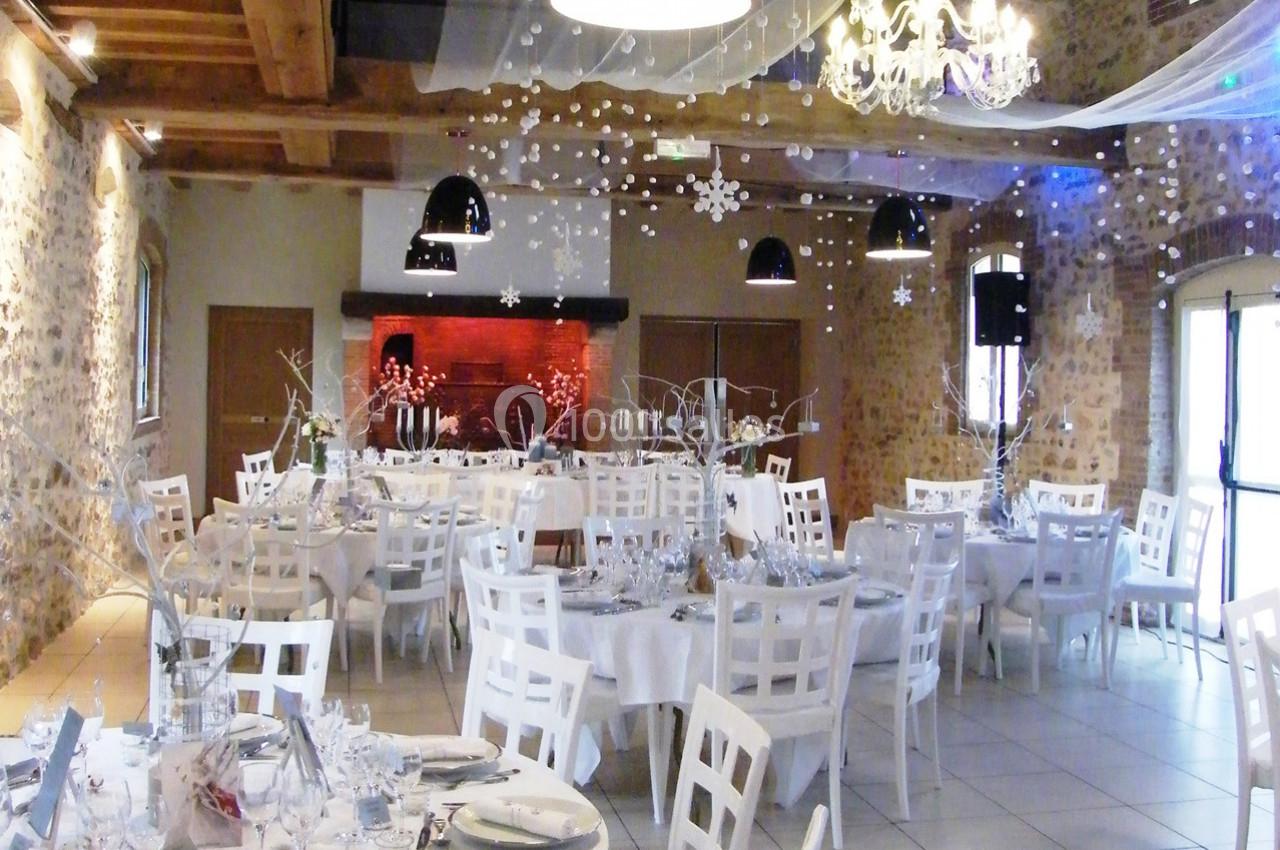 Location salle La Villeneuve-en-Chevrie (Yvelines) - La Grange des Mollières #21 Salle de réception décorée pour un événement, avec tables rondes, chaises blanches et ornements suspendus.