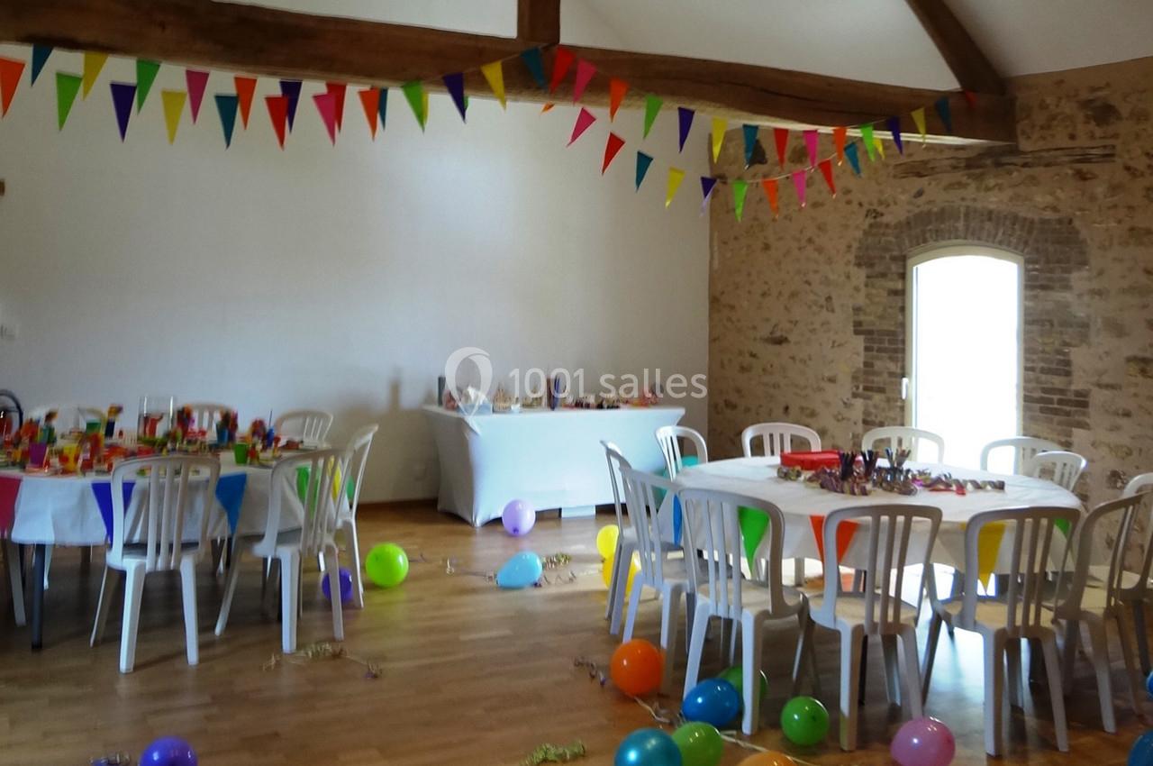 Location salle La Villeneuve-en-Chevrie (Yvelines) - La Grange des Mollières #18 Salle décorée pour une fête avec des tables dressées, des guirlandes colorées et des ballons au sol.