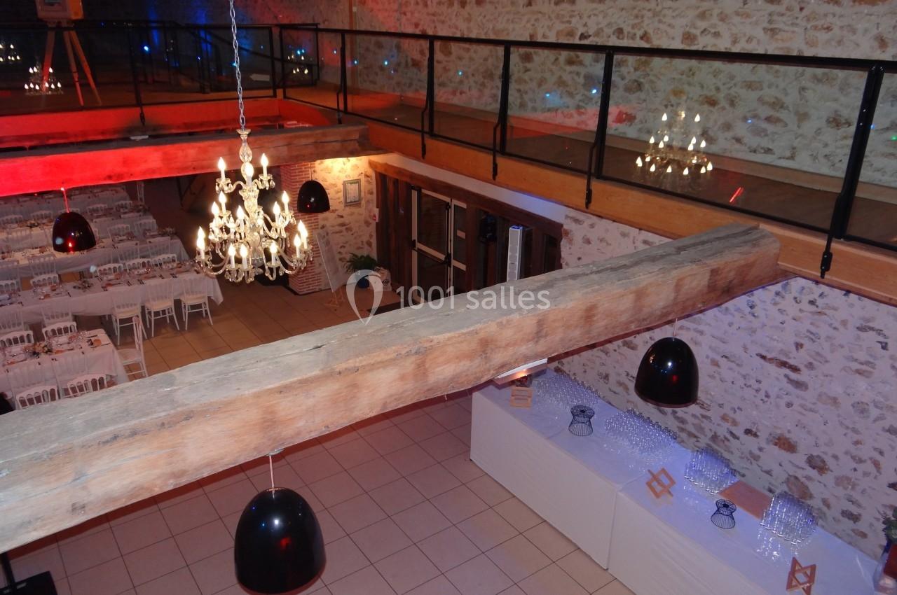 Location salle La Villeneuve-en-Chevrie (Yvelines) - La Grange des Mollières #37 Salle de réception avec tables dressées, lustres suspendus et mezzanine en bois et verre.