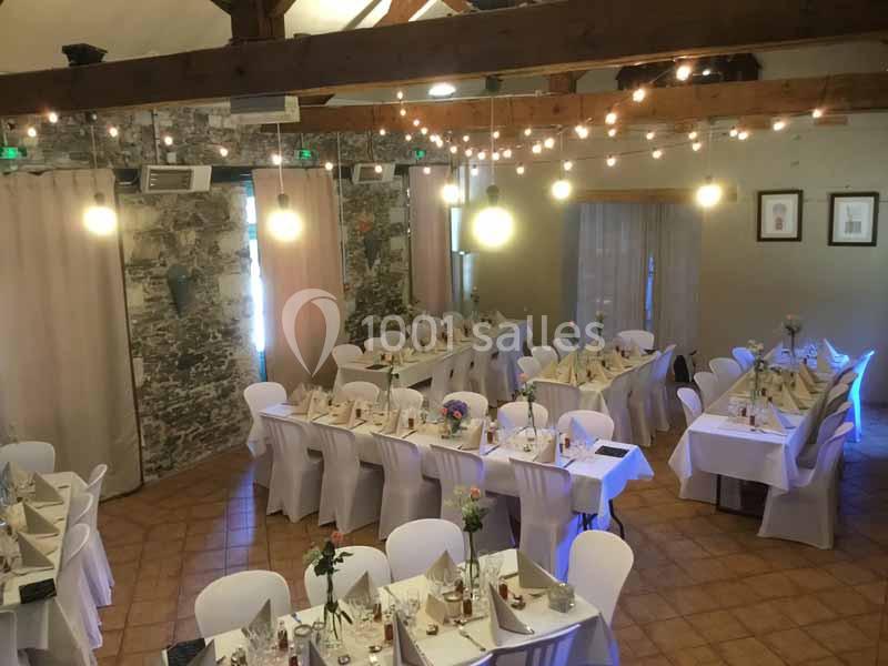 Location salle Haute-Goulaine (Loire-Atlantique) - La Cour des Montys #3 Salle de réception décorée avec des guirlandes lumineuses, des tables dressées et des chaises blanches.