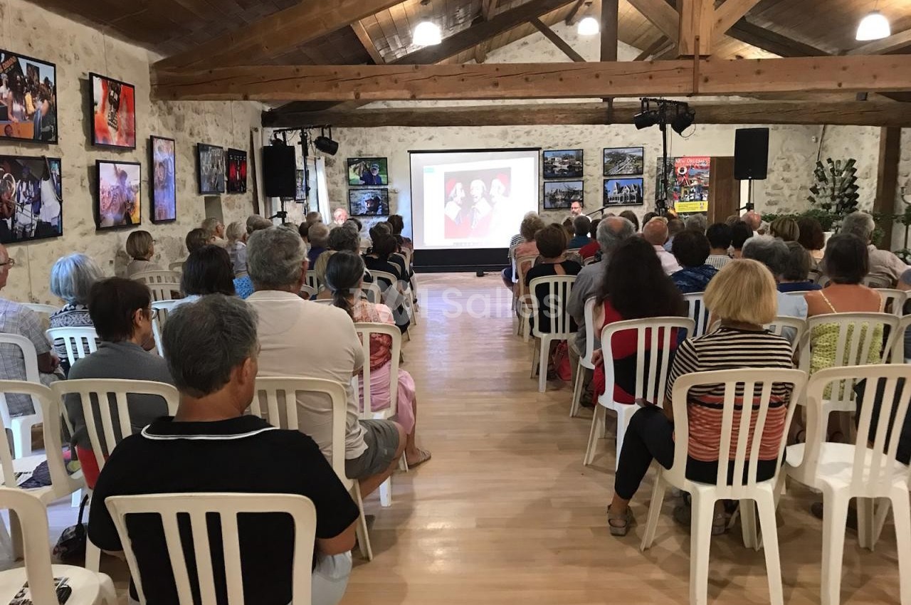 Un groupe de personnes assises dans une salle regardant une projection sur un écran.