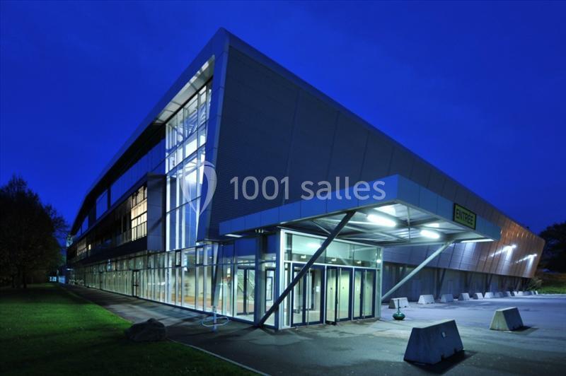 Location salle Nantes (Loire-Atlantique) - Exponantes Le Parc #3 Bâtiment moderne éclairé de nuit avec une façade vitrée et une entrée principale visible au premier plan.