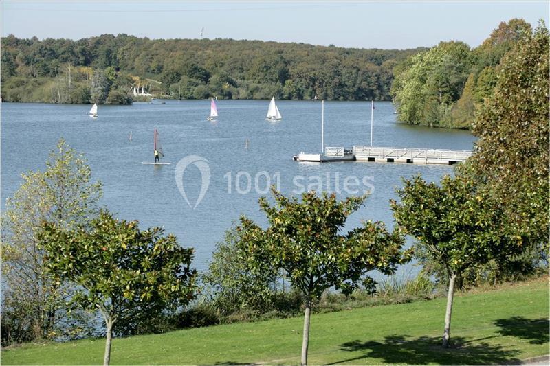 Location salle Nantes (Loire-Atlantique) - Exponantes Le Parc #14 Plan d'eau bordé d'arbres avec des voiliers et une planche à voile, près d'un ponton en bois.