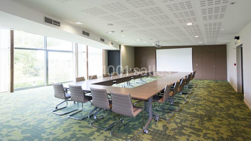 Location salle Nantes (Loire-Atlantique) - Exponantes Le Parc #17 Salle de réunion lumineuse avec une grande table rectangulaire, des chaises modernes et un écran de projection.