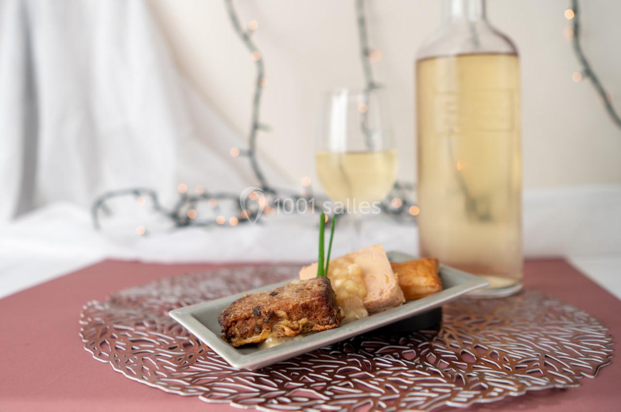 Location salle Donceel (Liège) - Château de Limont #4 Assiette de dégustation avec foie gras, pain grillé et accompagnements, servie avec un verre et une bouteille de vin blanc.